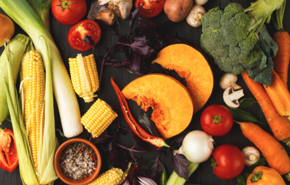 Assorted fresh fruits and vegetables on a black background