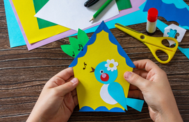 creating a birdhouse craft with construction paper