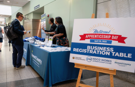 Employees from the Office of Workforce Development speaking to attendees at the Business Registration Table.