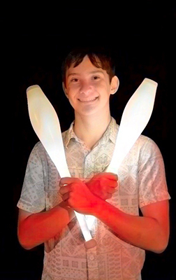 Performer Aryeh holding glowing pins