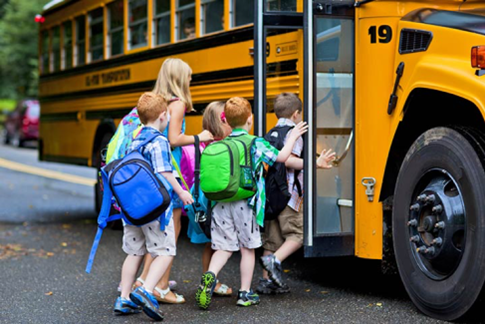 group of students climb onto a school bus