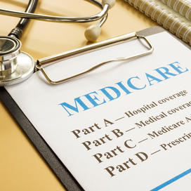 Stethoscope and clipboard with paper that says Medicare: part A, part B, part C, part D
